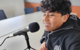 Young teen in front of a microphone.