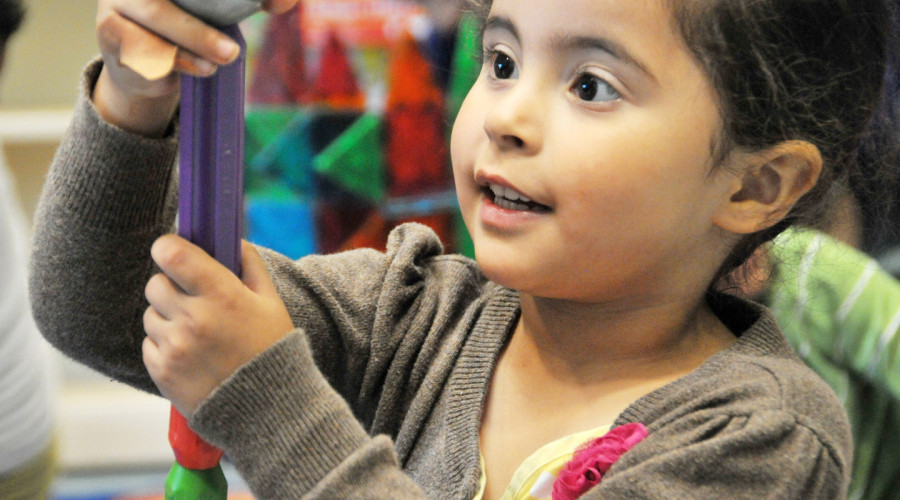 Curious little girl holding a toy