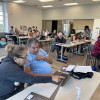 Adults and volunteers working together on computers