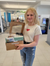 Photo of a teen girl posing with her prizes for being selected as one of the top entries for the Graphic Novel Contest.