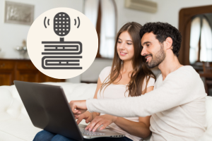 A man and woman sitting down and looking at a computer together with an icon of a microphone on top of books to the left