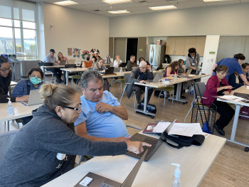 Adults and volunteers working together on computers