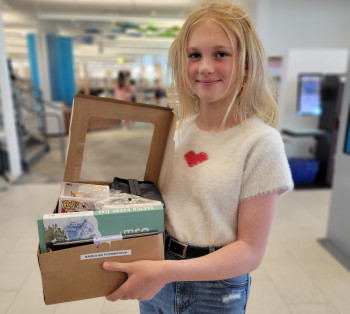 Photo of a teen girl posing with her prizes for being selected as one of the top entries for the Graphic Novel Contest.